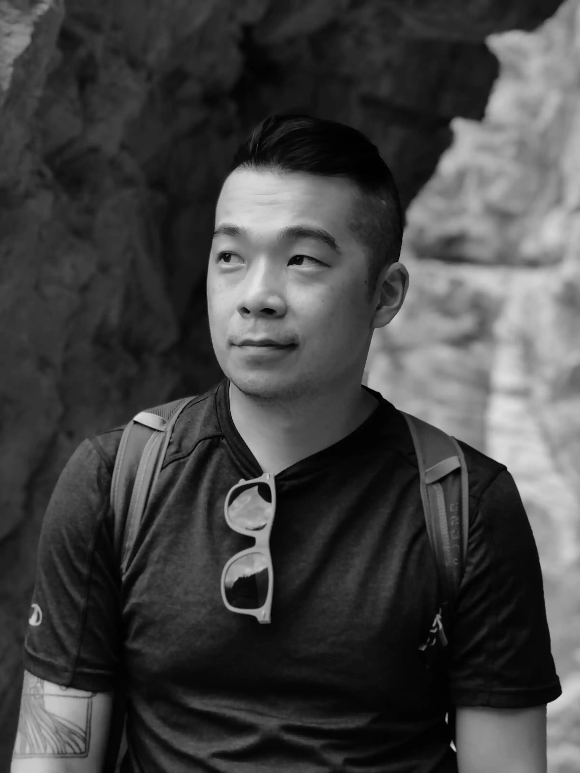A portrait of a clean-cut Asian-American man in his 40s. Behind him is Arches National Park.